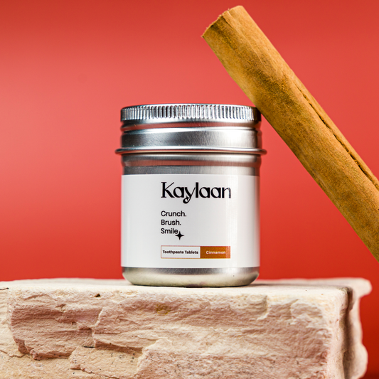 Jar of Kaylaan products with a cinnamon stick on a red background